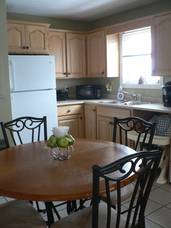 The left side of the kitchen cupboards from the refridgerator to the sink.